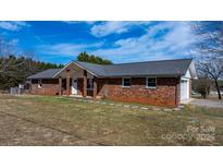 Charming brick home with a metal roof and well-maintained front yard at 2028 Hendil St, Conover, NC 28613