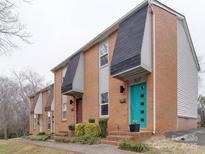 Brick townhouse exterior showcasing a row of homes with tidy landscaping and colorful doors at 307 French St, Charlotte, NC 28216