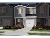 Charming gray two-story townhome featuring a one-car garage and beautifully landscaped front yard at 5013 Kellaher Pl, Charlotte, NC 28216