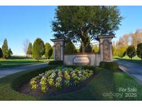Welcoming Cheval community entrance featuring beautiful landscaping and stone accents at 5926 Long Stirrup Ln, Mint Hill, NC 28227