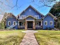 Charming blue two-story home with a welcoming front porch and manicured lawn in a desirable neighborhood at 8002 Pemswood St, Charlotte, NC 28277