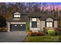 Charming gray brick home with a two-car garage, black trim, mature landscaping and well-maintained lawn at 9334 Hunting Ct, Matthews, NC 28105