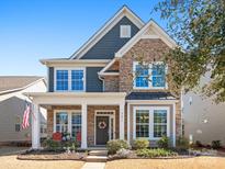 Charming two-story home featuring stone accents, covered porch, and professionally landscaped front yard at 9611 Rayneridge Dr, Huntersville, NC 28078