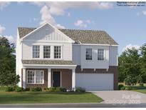 This two-story home boasts a brick and white facade, attached two-car garage, and is surrounded by a lush green lawn at 1201 Blackburn Cir, Edgemoor, SC 29712