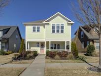 Charming two-story home with inviting porch, manicured landscaping, and a light green facade at 1538 Riverwalk Pkwy, Rock Hill, SC 29730