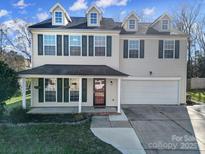 Charming two-story home featuring dormer windows, green shutters, a welcoming porch, and an attached garage at 1766 Canebrook Gln, York, SC 29745