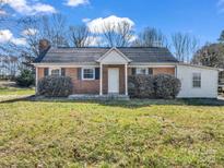 Charming brick home featuring a new roof, well-maintained landscaping, and a welcoming front entrance at 2100 Lincolnton Hwy, Cherryville, NC 28021