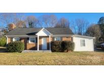 Charming brick home featuring a well-maintained lawn, inviting entrance, and classic architectural details at 2100 Lincolnton Hwy, Cherryville, NC 28021