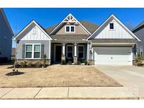 Charming single-Gathering home boasts stone accents, gray siding, and a well-manicured front yard at 3309 Juneberry Pl, Indian Land, SC 29707