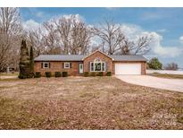 Charming single-story brick home featuring a well-manicured lawn, mature trees, and a two-car garage at 342 Monticello Rd, Statesville, NC 28625
