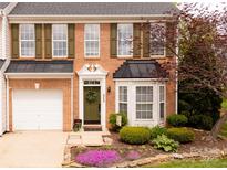 Charming brick townhome with olive shutters, black awnings, and professionally landscaped front yard at 4022 Carl Parmer Dr, Harrisburg, NC 28075