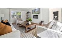 Bright living room features a fireplace, TV, modern furniture, and a large window for natural light at 4931 Baylor Dr, Charlotte, NC 28210