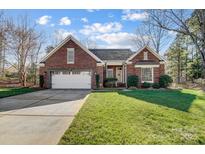 Charming brick home featuring an attached two-car garage and a well-manicured front lawn at 6038 Burnt Mill Run, Matthews, NC 28104