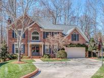 Stately brick home featuring a manicured lawn, driveway, and attached garage at 8111 Sealey Ct, Charlotte, NC 28277