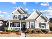 Charming two-story home featuring stone accents, a covered porch, and well-manicured landscaping at 136 Kingston Dr, Locust, NC 28097