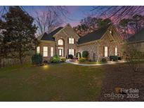 Beautiful brick and stone home with a well-manicured lawn, a water fountain, and professional landscaping at 170 Anniston Way, Davidson, NC 28036