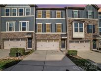 Charming townhome featuring a stone facade, three stories, and a one car garage at 1932 Catkin Ln, Charlotte, NC 28205
