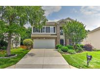 Charming two-story home featuring a well-maintained lawn, landscaped yard and an attached two-car garage at 2017 Bridleside Dr, Indian Trail, NC 28079