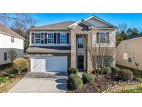 Charming two-story home featuring a brick facade, two-car garage, and well-maintained landscaping at 2017 Bridleside Dr, Indian Trail, NC 28079