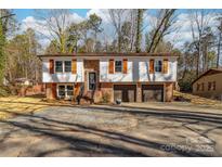 Charming split-level home featuring a brick foundation, two-car garage, and white horizontal siding at 205 Redding Rd, Stanley, NC 28164