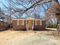 Charming brick home with boarded windows, offering renovation potential and investment opportunities at 2207 Madrid St, Charlotte, NC 28216