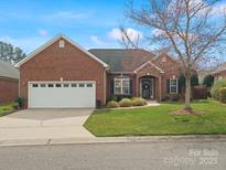 Charming brick home featuring a two-car garage, manicured lawn, and inviting front entrance at 2210 Pinefield Ct, Gastonia, NC 28056