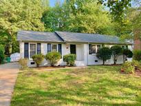 Charming single-story home featuring a brick facade, manicured lawn, and mature trees at 2314 Knickerbocker Dr, Charlotte, NC 28212