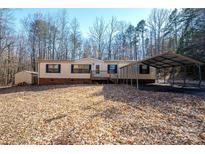 A cozy single-story home with a carport and a small storage shed nestled among the trees at 237 Creekstone Ln, York, SC 29745