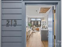 A view through the open doorway shows the kitchen island and living space with balcony beyond at 2401 Euclid Ave # 213, Charlotte, NC 28203