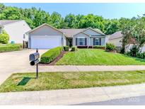 Charming single-story home with a well-manicured lawn, neatly trimmed bushes, and a two-car garage at 2627 Bridgeville Ln, Charlotte, NC 28262