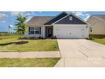 Charming single-story home featuring a two-car garage and well-manicured front lawn at 324 Aniston Ln, Shelby, NC 28152