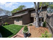 Charming home with a lush backyard, stone patio, and comfortable outdoor seating area at 5306 Wingedfoot Rd, Charlotte, NC 28226