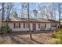 Charming single-story home featuring neutral siding, red shutters, and an attached garage at 6817 Fieldlark Ln, Charlotte, NC 28227