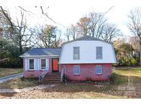 Charming two-story home with a brick facade, a cozy covered entry, and a well-lit and spacious yard at 7006 Idlewild Rd, Charlotte, NC 28212