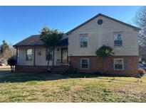 Two-story home with brick and vinyl siding and a well-maintained front lawn at 7426 Riding Trail Rd, Charlotte, NC 28212