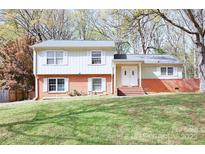 Charming two-story home featuring a well-manicured lawn and a classic brick and siding facade at 7515 Riding Trail Rd, Charlotte, NC 28212