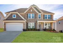 Beautiful two-story home featuring stone accents, attached garage, landscaped front yard and a welcoming front porch at 7672 Tanglewood Way, Denver, NC 28037