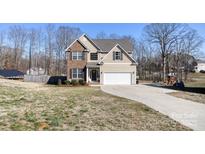 Charming two-story home featuring brick accents, neutral siding, and an attached two-car garage at 8822 Crape Myrtle Dr, Stanfield, NC 28163