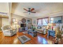 Cozy living room featuring hardwood floors, neutral walls, and comfortable furnishings at 1049 Ramsey St, Stanley, NC 28164
