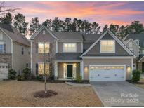 Inviting two-story home boasts a manicured lawn, two-car garage, and lovely curb appeal at 1189 Sandy Bottom Nw Dr, Concord, NC 28027