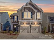 Beautiful two-story home featuring two-car garage, stone accents, and charming architectural details, creating curb appeal at 1232 Scotch Meadows Loop, Monroe, NC 28110