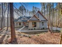 Stunning exterior view of a stone and gray home with a walkway and landscaping at 1547 Sunset Pointe Dr, Salisbury, NC 28146