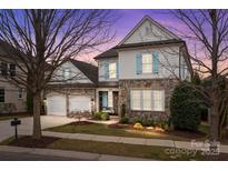Charming two-story home with stone accents, light blue shutters, and a well-manicured front yard at 15913 Robbins Green Dr, Cornelius, NC 28031
