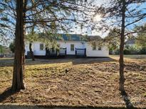 A backyard featuring a two-story home with a black deck, surrounded by a partially grassy yard at 200 Hillcrest Ave, Hickory, NC 28601