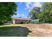 Charming brick home with green shutters and a covered carport, nestled under mature trees at 208 Caleb Rd, Shelby, NC 28152