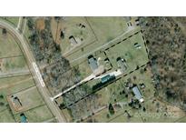 Expansive property featuring multiple structures, a long driveway, and mature trees, offering privacy and potential at 231 John E Randall Rd, Shelby, NC 28152