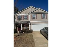 Charming two-story home with a two-car garage, American flag, and well-maintained lawn on a sunny day at 3627 Alexander Forest Dr, Charlotte, NC 28269