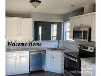 Updated kitchen features white cabinets, stainless steel appliances, and granite countertops at 4226 Red Shed Ln, Charlotte, NC 28269