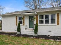 Charming, white painted brick home with wooden shutters and a welcoming front porch at 5622 S Rocky River Rd, Monroe, NC 28112