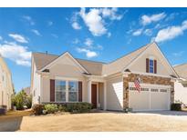 Charming exterior with stone accents, a two-car garage, manicured lawn, and an American flag at 7336 Overjoyed Xing, Charlotte, NC 28215